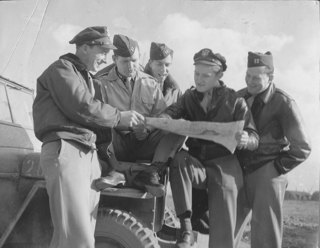 Harry Crosby, second from right, studies a map with other U.S. Army Air Forces navigators during World War II.