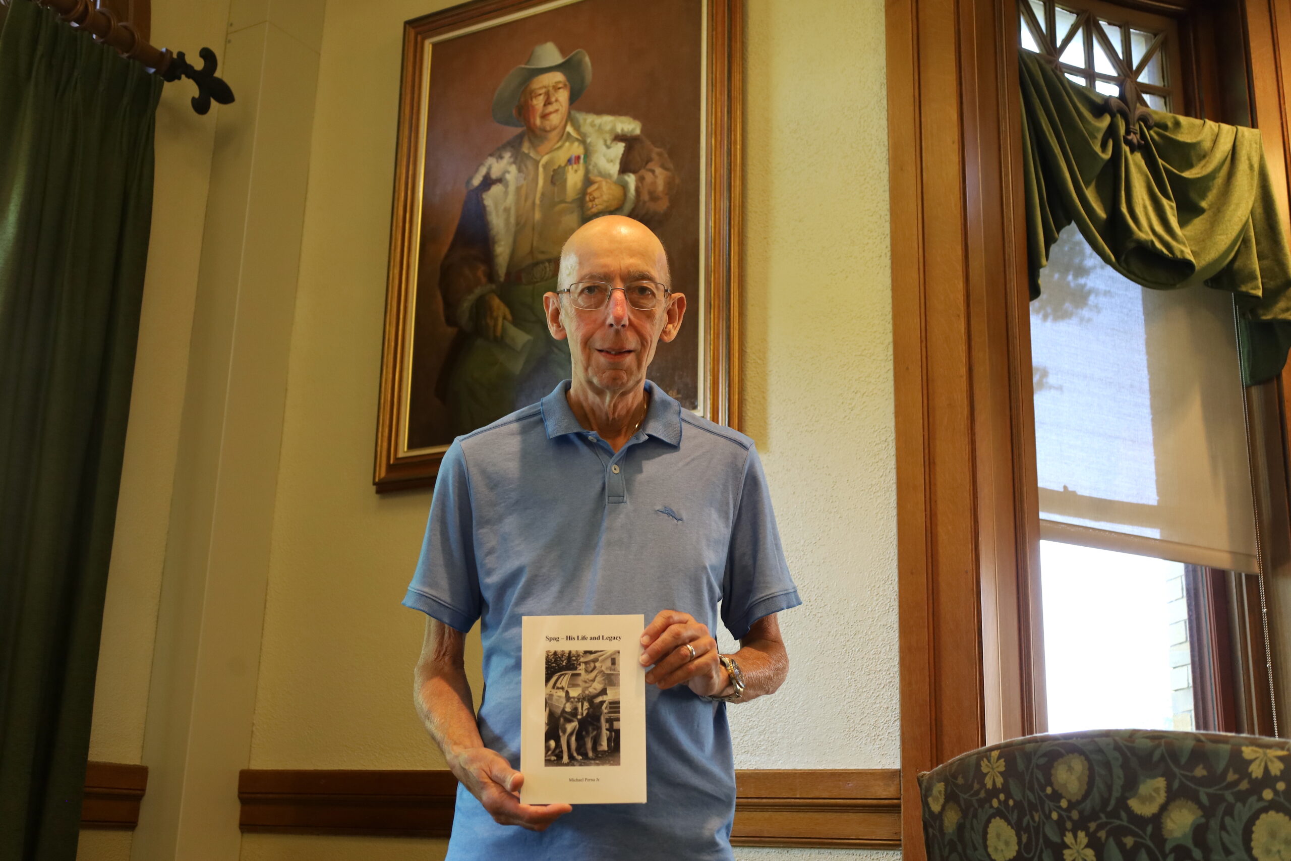 Michael Perna Jr. stands with his new book beside a picture of Anthony “Spag” Borgatti located at the Shrewsbury Public Library. (Photo/Evan Walsh)